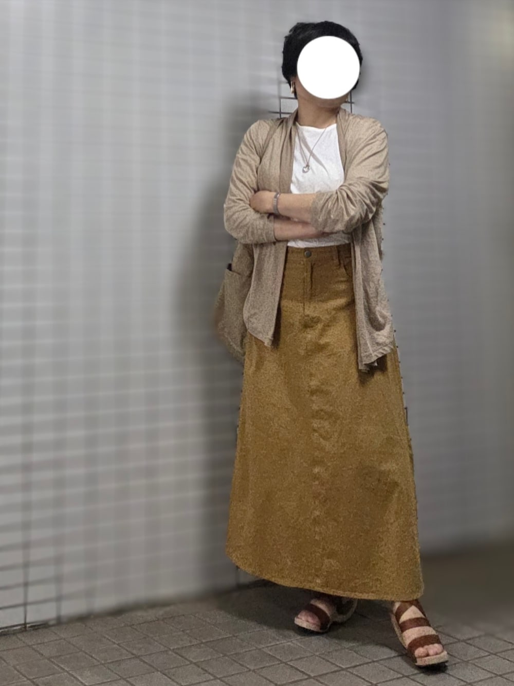ベージュ系のショルダーバッグ、ベージュ系のスカート、ブラウン系のサンダルを着用したレディースの秋コーディネートの2枚目の写真