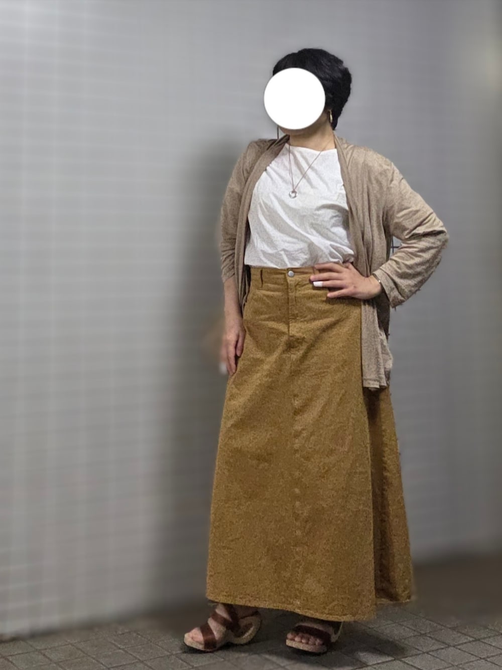 ベージュ系のショルダーバッグ、ベージュ系のスカート、ブラウン系のサンダルを着用したレディースの秋コーディネートの3枚目の写真