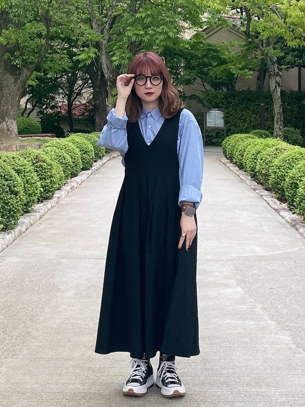 ブラック系のワンピース、ブルー系のシャツ/ブラウス、ブラック系のスニーカーを着用したレディースの春コーディネートの2枚目の写真