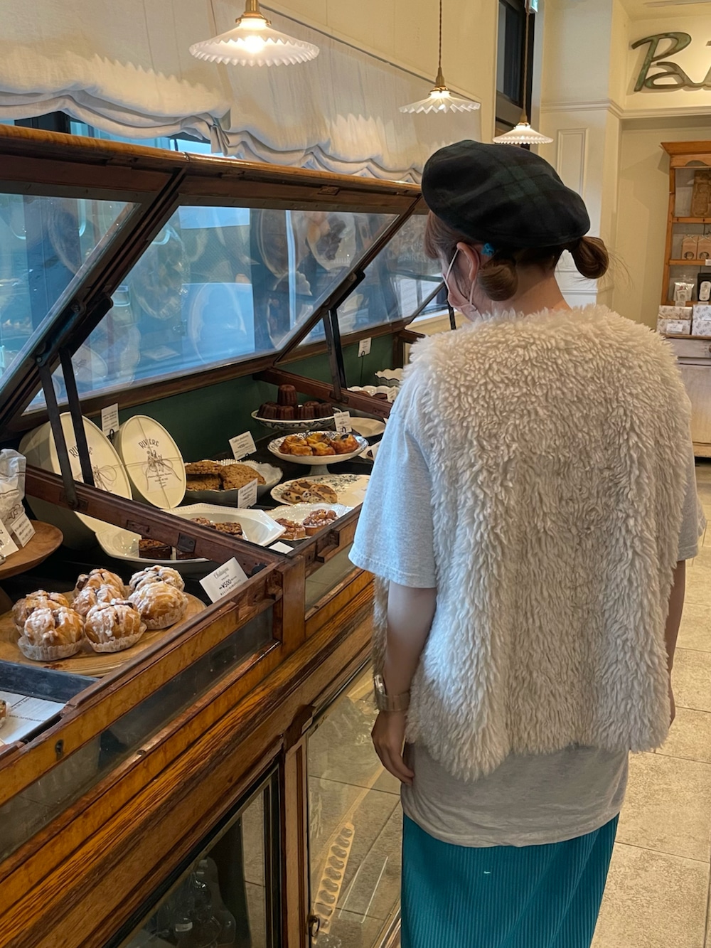 ホワイト系のベスト、グレー系のTシャツ/カットソー、ブラック系のショルダーバッグを着用したレディースの秋コーディネートの4枚目の写真