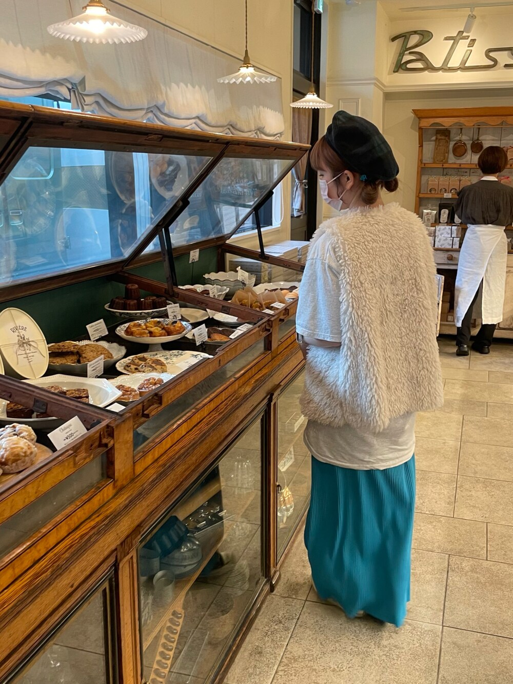 ホワイト系のベスト、グレー系のTシャツ/カットソー、ブラック系のショルダーバッグを着用したレディースの秋コーディネートの5枚目の写真