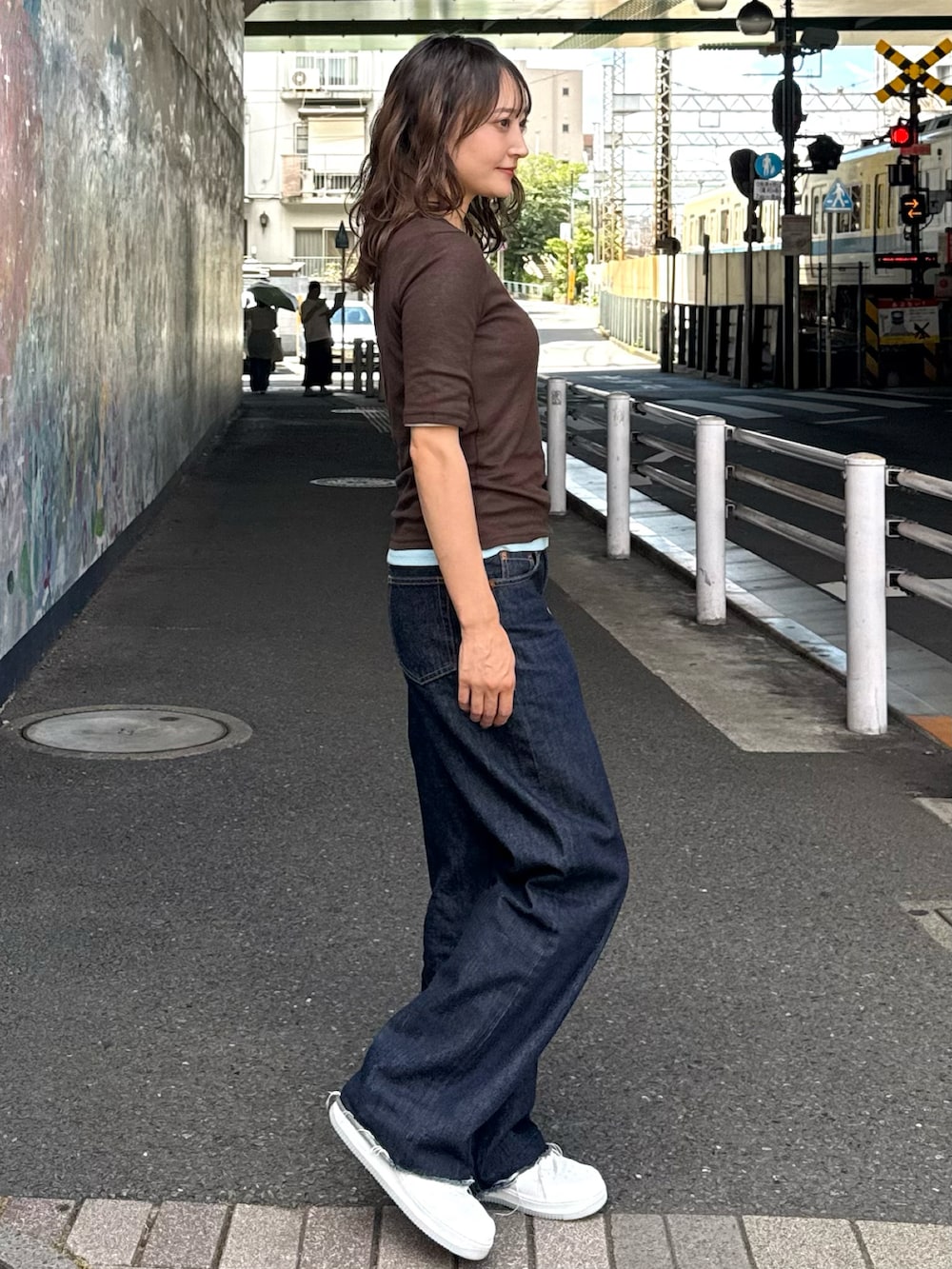 ホワイト系のスニーカー、ブルー系のTシャツ/カットソー、ブルー系のデニムパンツを着用したレディースの夏コーディネートの3枚目の写真