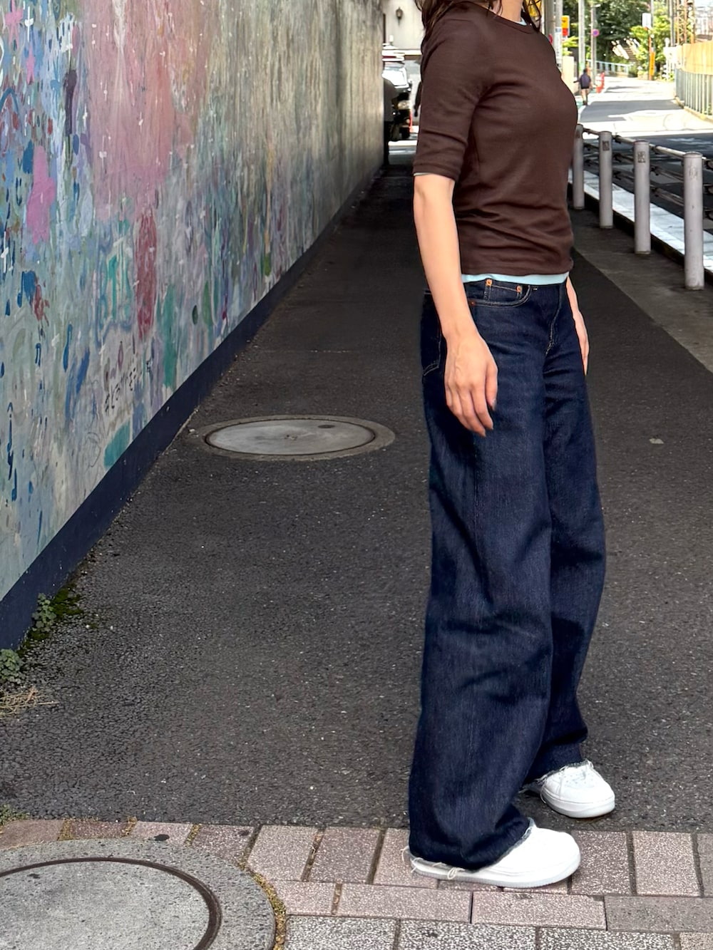 ホワイト系のスニーカー、ブルー系のTシャツ/カットソー、ブルー系のデニムパンツを着用したレディースの夏コーディネートの2枚目の写真