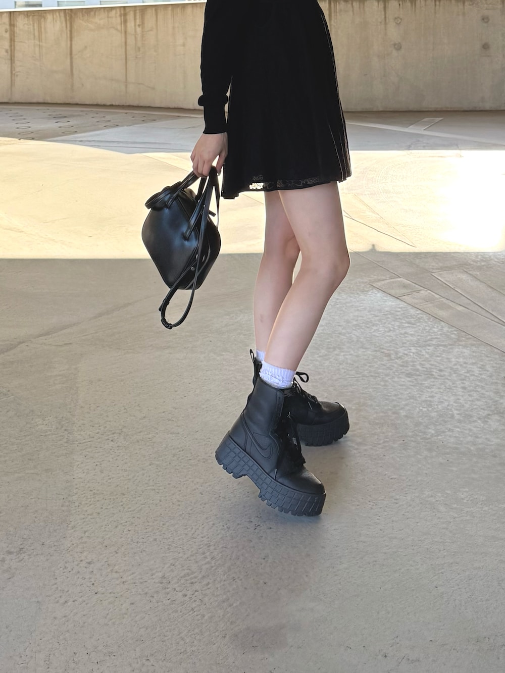 ブラック系のスニーカーを着用したレディースの秋コーディネートの2枚目の写真