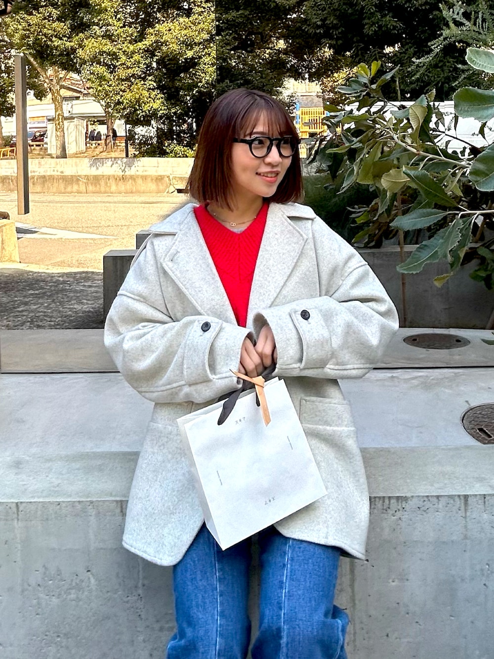 ブルー系のデニムパンツ、ブラウン系のブーツ、シルバー系のショルダーバッグを着用したレディースの冬コーディネートの2枚目の写真