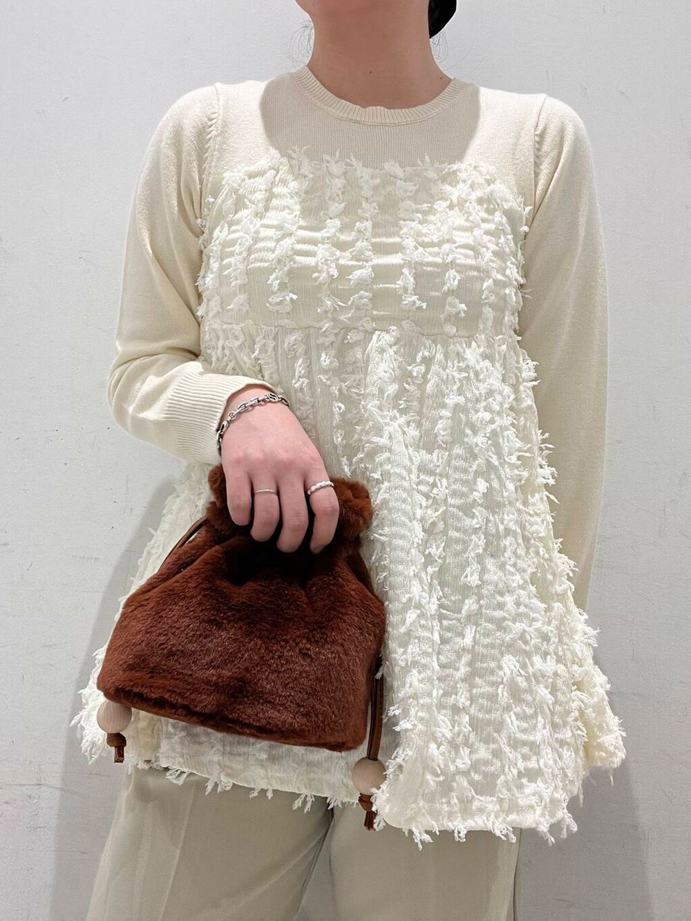 ベージュ系のその他パンツ、ブラウン系のブーツ、ブラウン系のショルダーバッグを着用したレディースの冬コーディネートの3枚目の写真