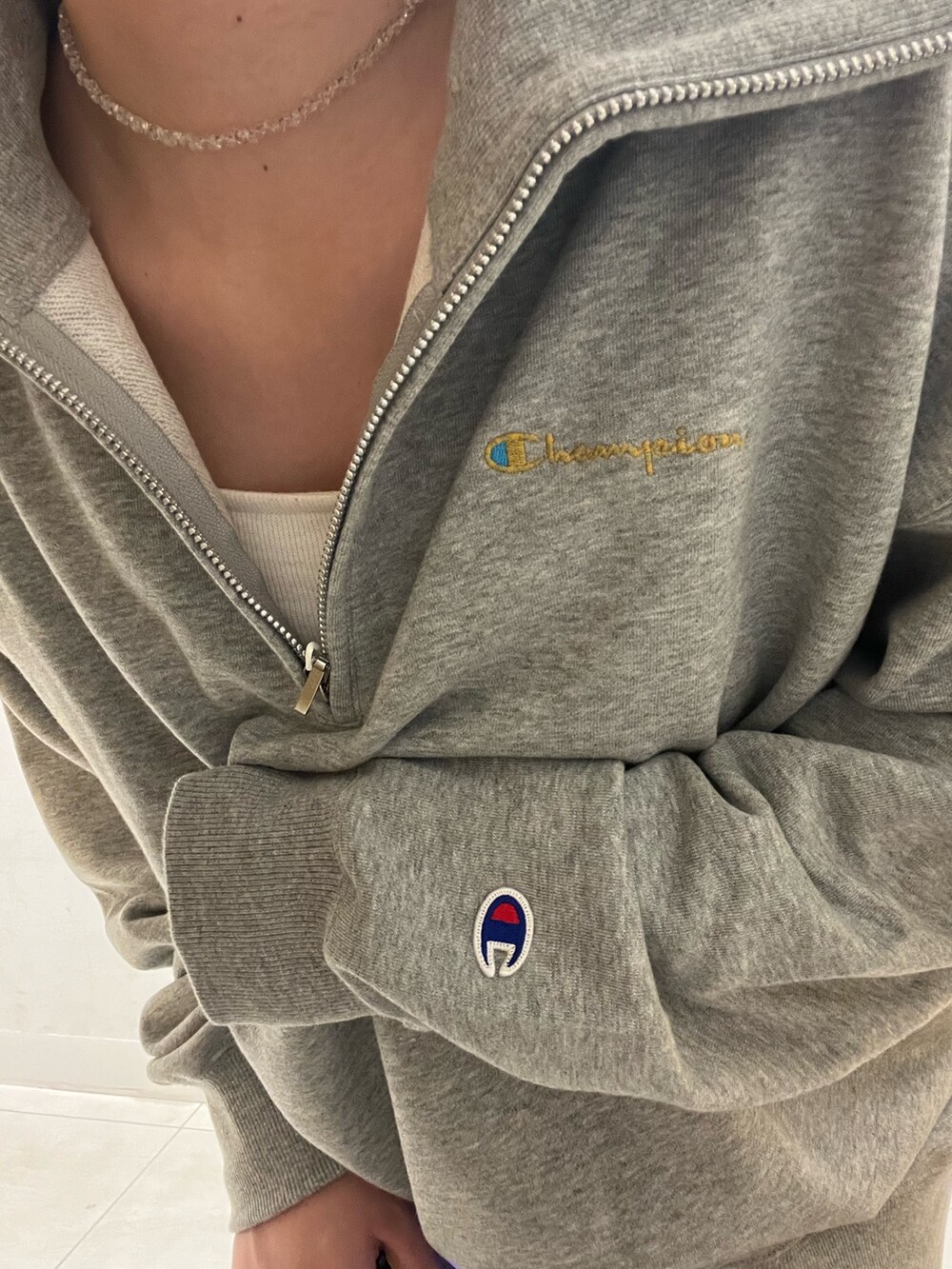 グレー系のスウェット、ブラック系のスカート、ベージュ系のハンドバッグを着用したレディースの秋コーディネートの2枚目の写真