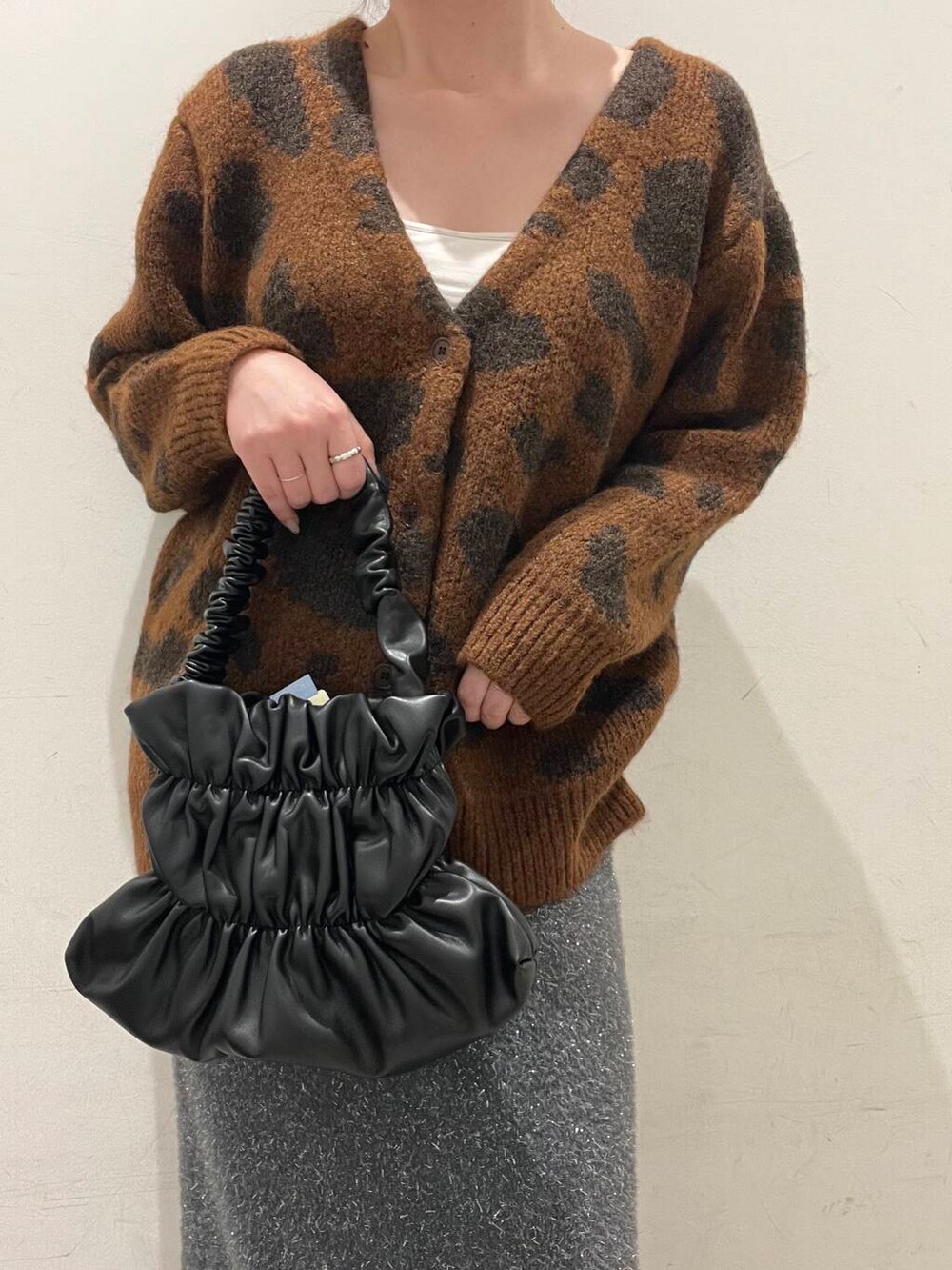 ブラック系のハンドバッグ、グレー系のスカート、ブラウン系のカーディガン/ボレロを着用したレディースの冬コーディネートの3枚目の写真