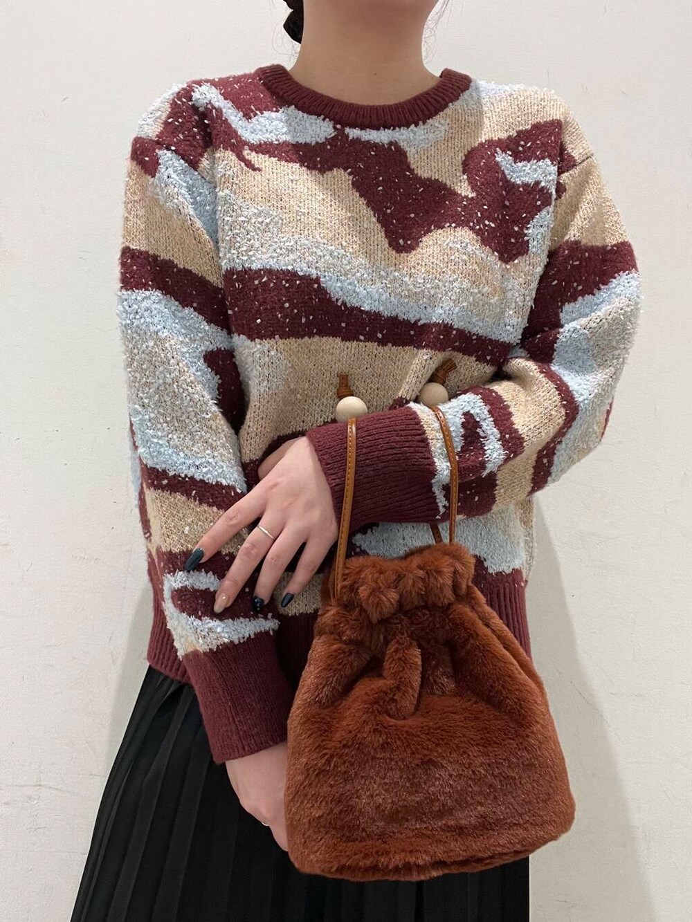 ピンク系のニット/セーター、ブラウン系のブーツ、ブラウン系のショルダーバッグを着用したレディースの冬コーディネートの3枚目の写真