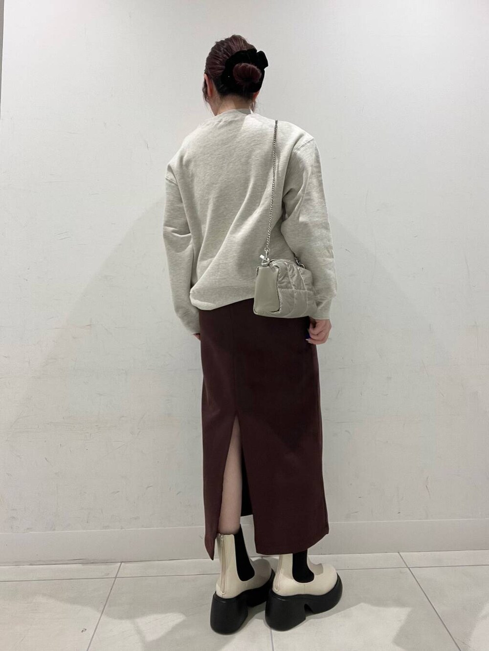 ホワイト系のブーツ、その他のスウェット、シルバー系のショルダーバッグを着用したレディースの冬コーディネートの2枚目の写真