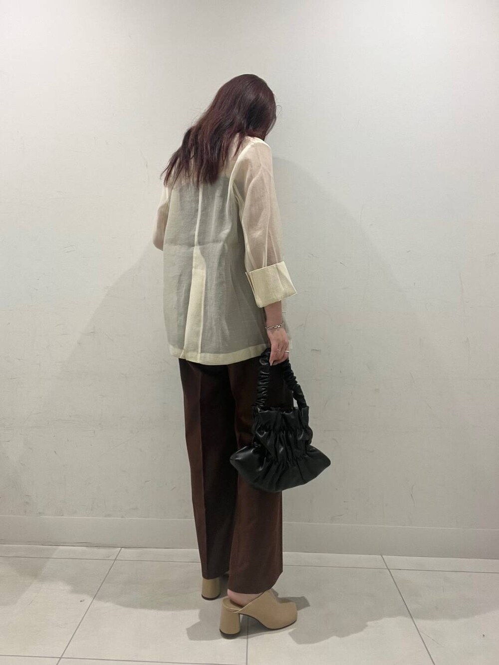 ブラック系のハンドバッグ、ブラウン系のキャミソール、ベージュ系のサンダルを着用したレディースの秋コーディネートの2枚目の写真