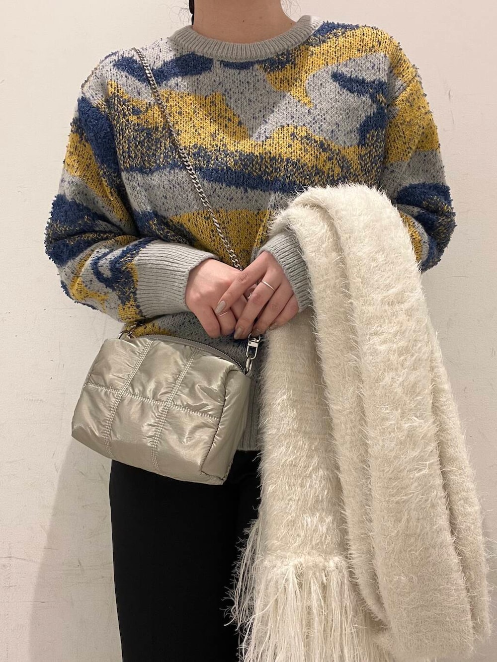 グレー系のニット/セーター、ホワイト系のブーツ、ブラック系のその他パンツを着用したレディースの冬コーディネートの3枚目の写真