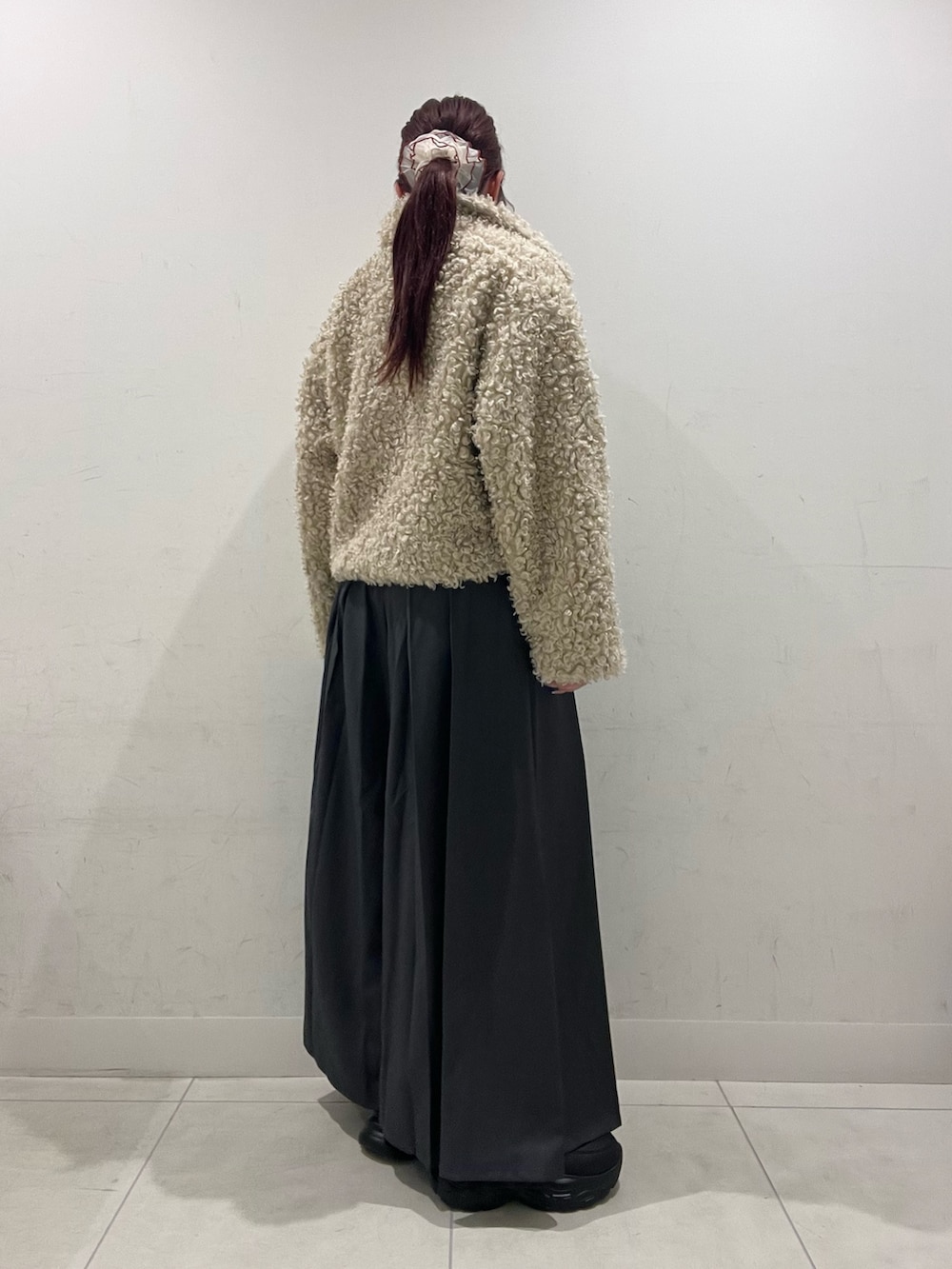 ホワイト系のその他アウター、ブルー系のニット/セーター、グレー系のその他パンツを着用したレディースの秋コーディネートの2枚目の写真