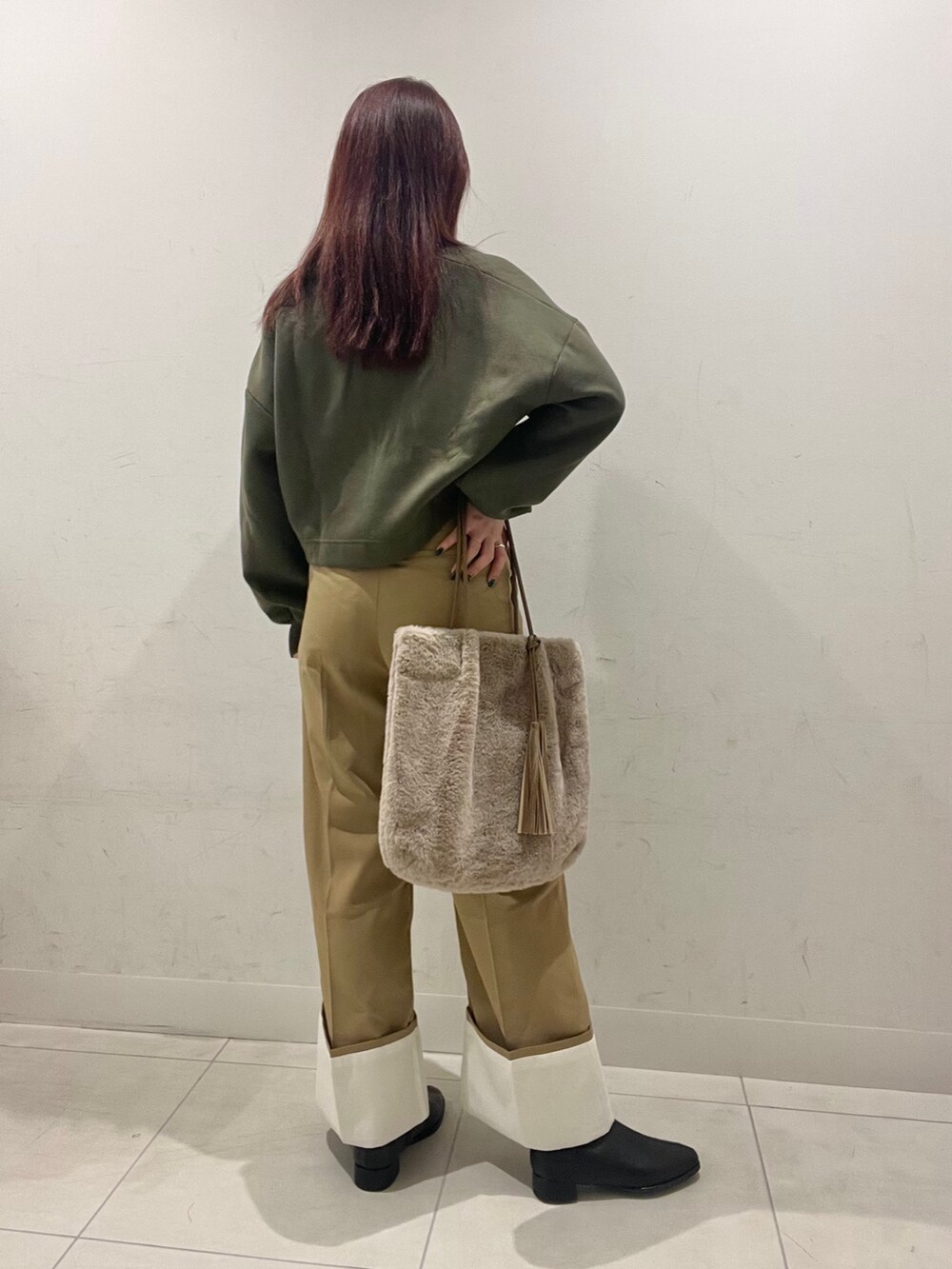 グリーン系のスウェット、ベージュ系のその他パンツ、ブラック系のブーツを着用したレディースの秋コーディネートの2枚目の写真