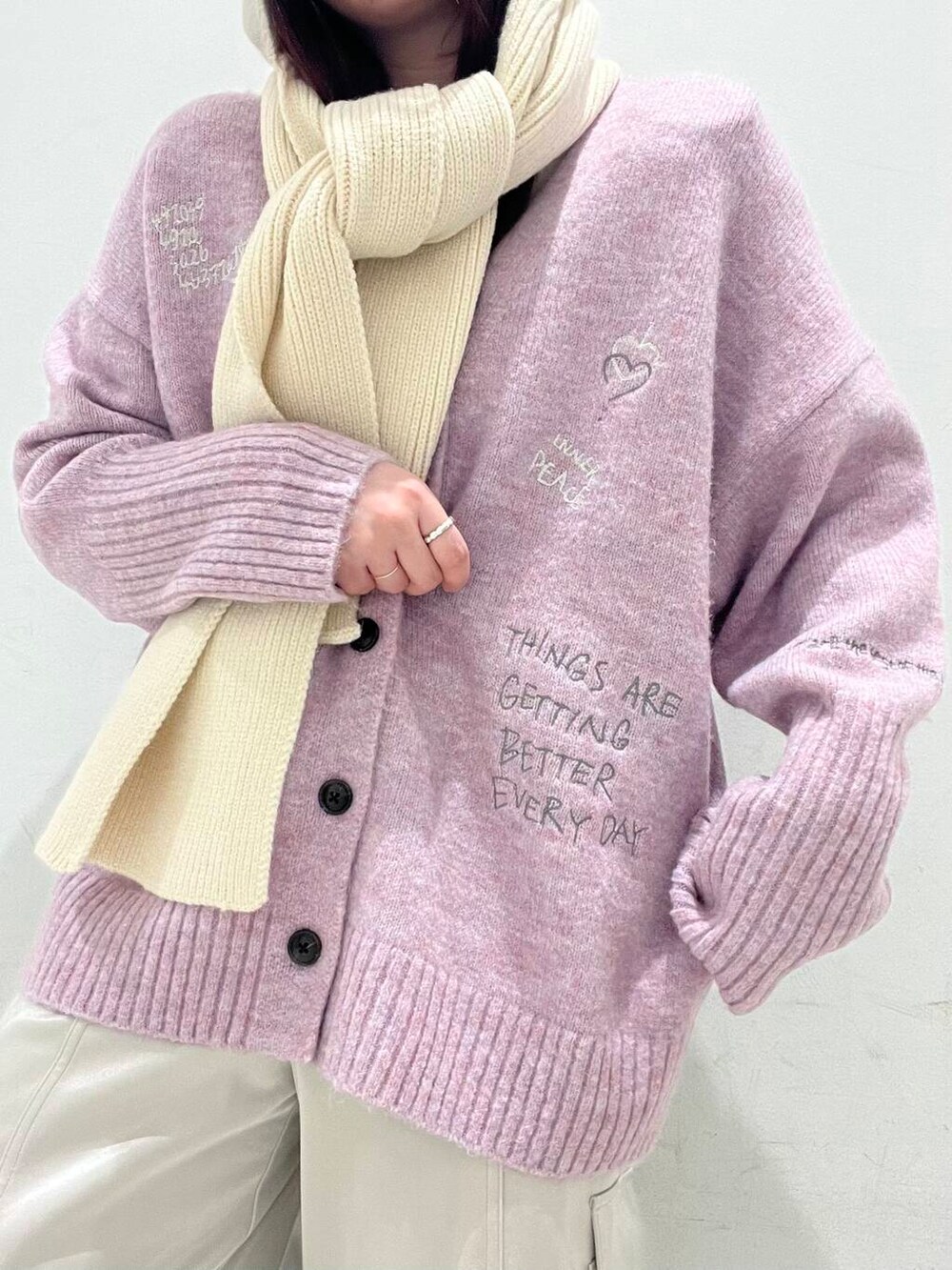 ブラック系のブーツ、ピンク系のカーディガン/ボレロ、ベージュ系のその他パンツを着用したレディースの冬コーディネートの3枚目の写真