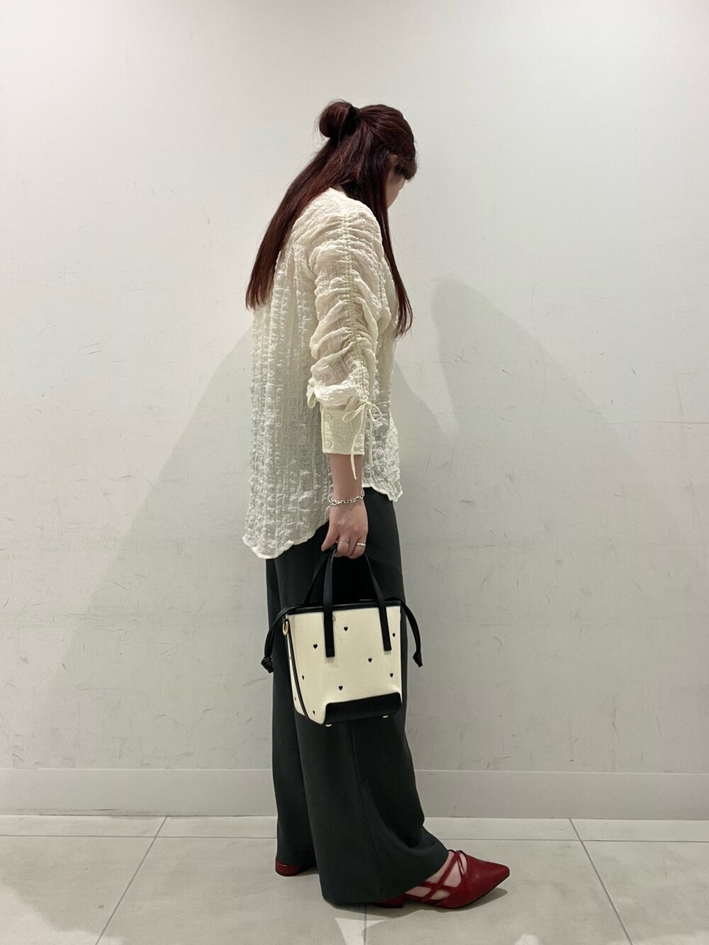 ホワイト系のシャツ/ブラウス、グレー系のその他パンツ、ブラック系のハンドバッグを着用したレディースの秋コーディネートの2枚目の写真