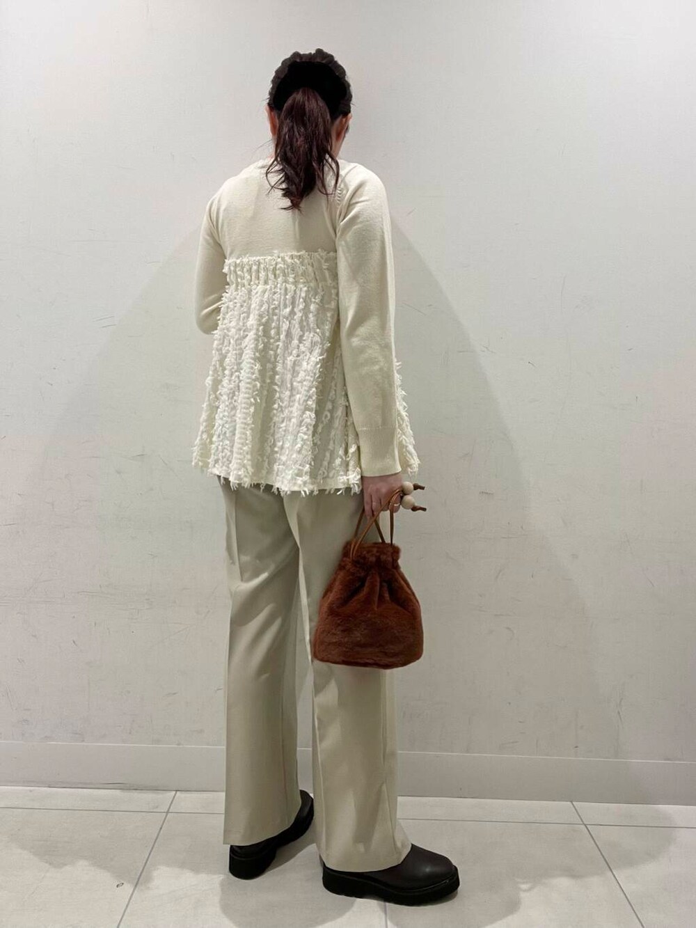 ベージュ系のその他パンツ、ブラウン系のブーツ、ブラウン系のショルダーバッグを着用したレディースの冬コーディネートの2枚目の写真