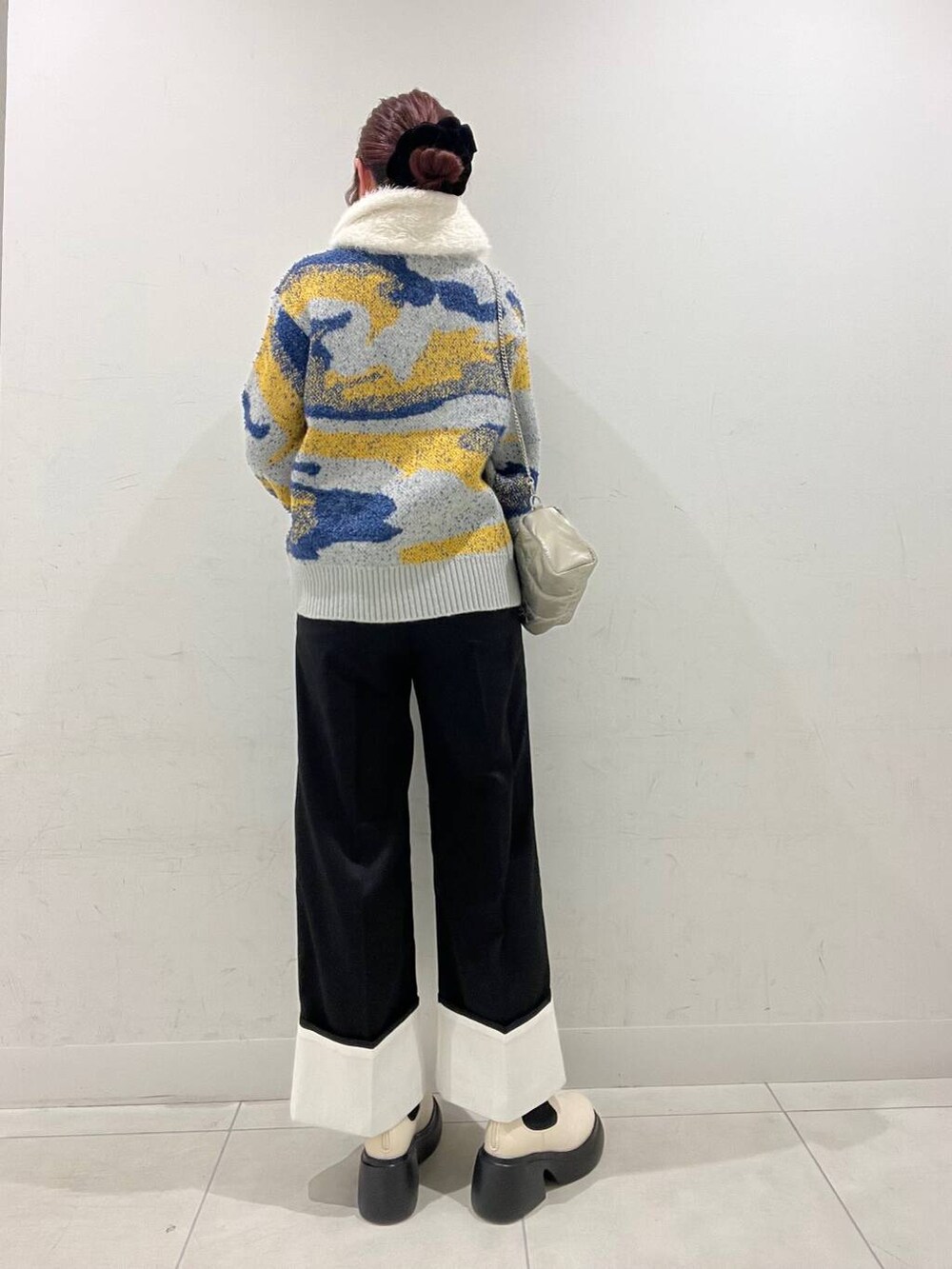 グレー系のニット/セーター、ホワイト系のブーツ、ブラック系のその他パンツを着用したレディースの冬コーディネートの2枚目の写真