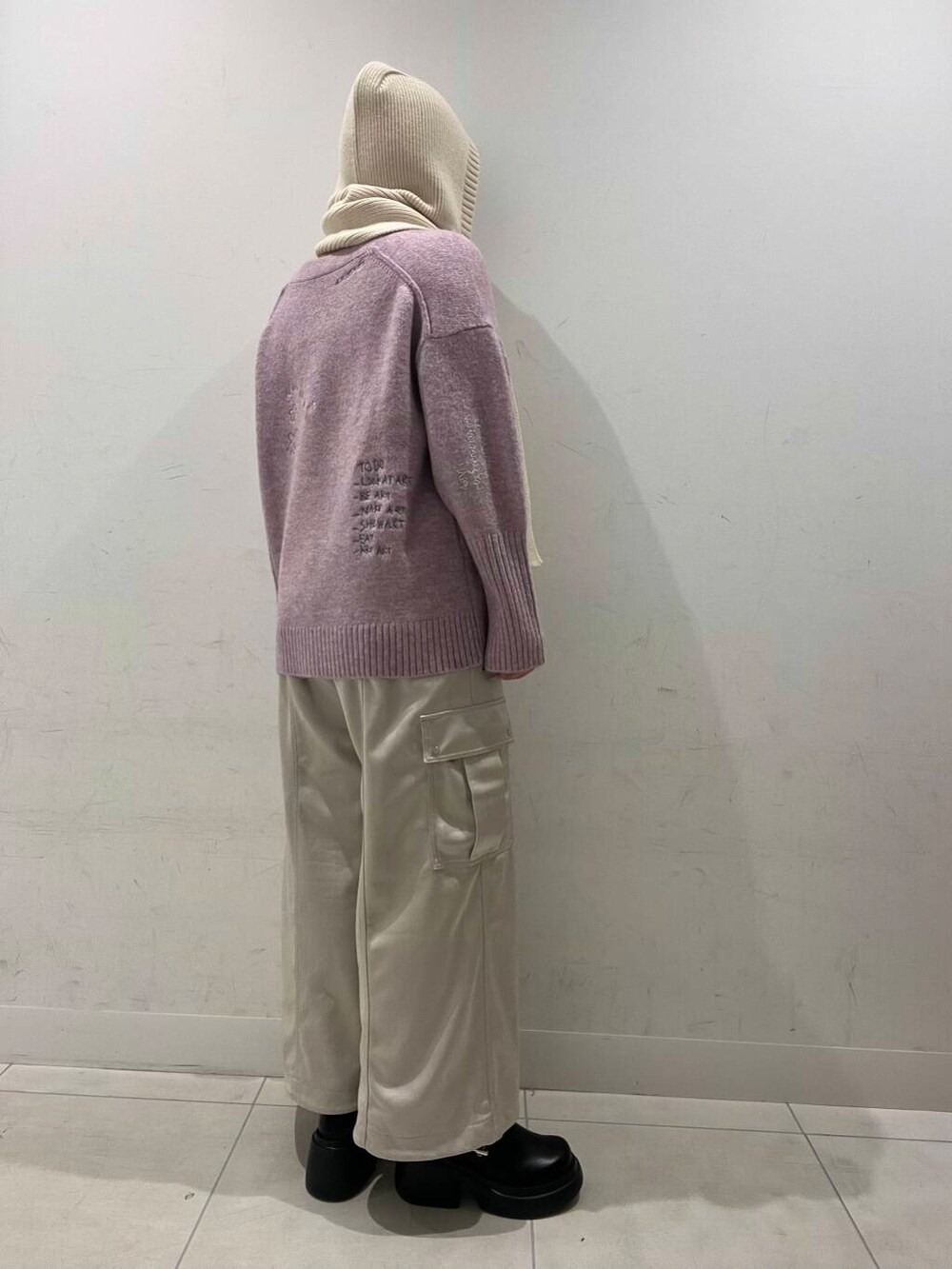 ブラック系のブーツ、ピンク系のカーディガン/ボレロ、ベージュ系のその他パンツを着用したレディースの冬コーディネートの2枚目の写真