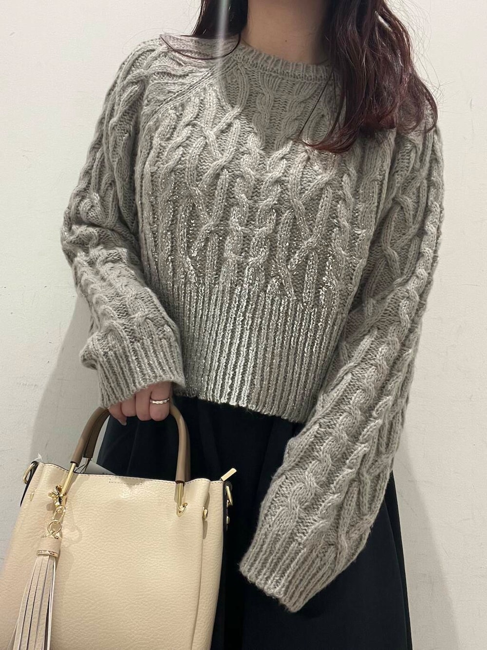 ホワイト系のトートバッグ、ブルー系のスカート、ブラック系のブーツを着用したレディースの冬コーディネートの3枚目の写真