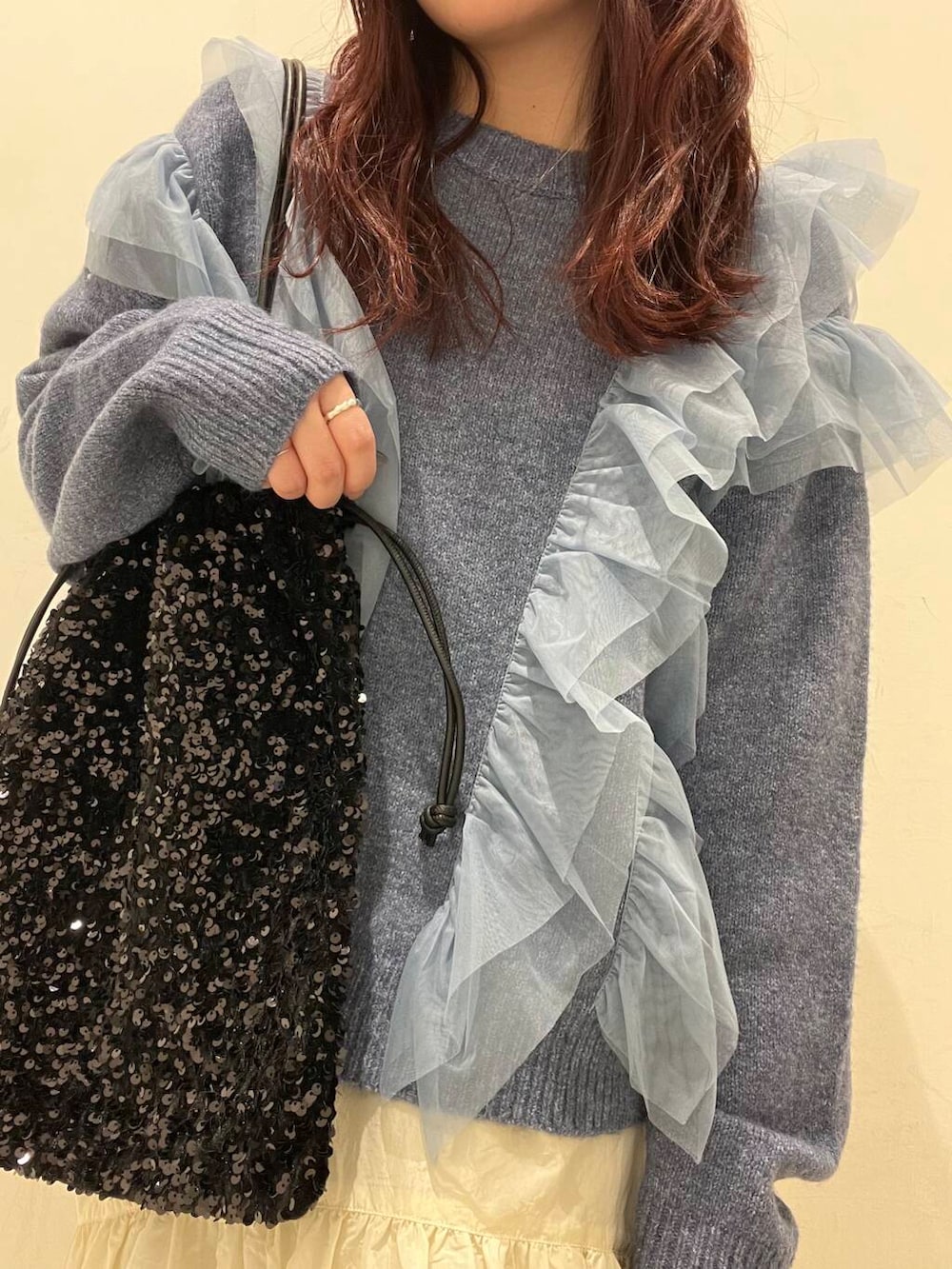 ブラック系のブーツ、ホワイト系のスカート、ブラック系のトートバッグを着用したレディースの冬コーディネートの3枚目の写真