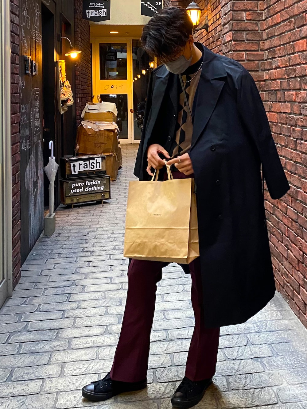 ブラウン系のトップス、ブラック系のジャケット/アウター、レッド系のパンツを着用したメンズの春コーディネートの2枚目の写真