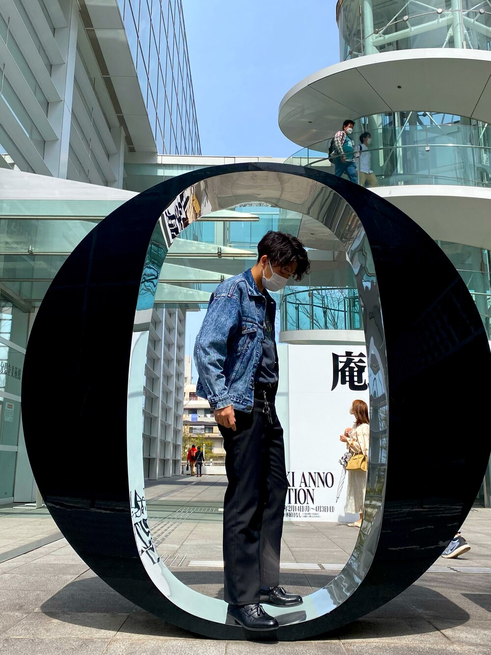 ブルー系のデニムジャケット、ブラック系のパンツを着用したメンズの春コーディネートの3枚目の写真