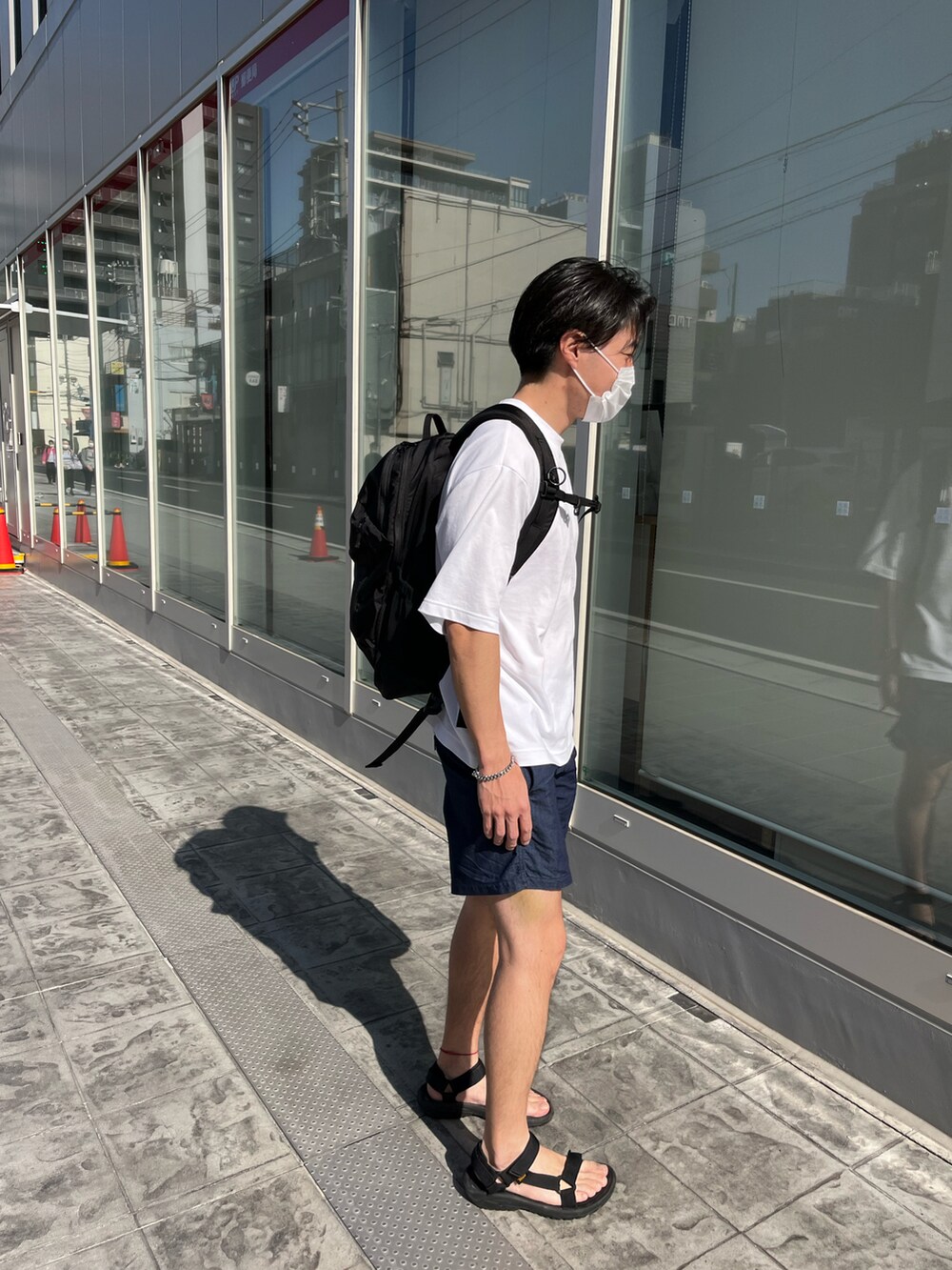 ブラック系のサンダル、ブルー系のその他パンツ、ホワイト系のTシャツ/カットソーを着用したメンズの春コーディネートの3枚目の写真