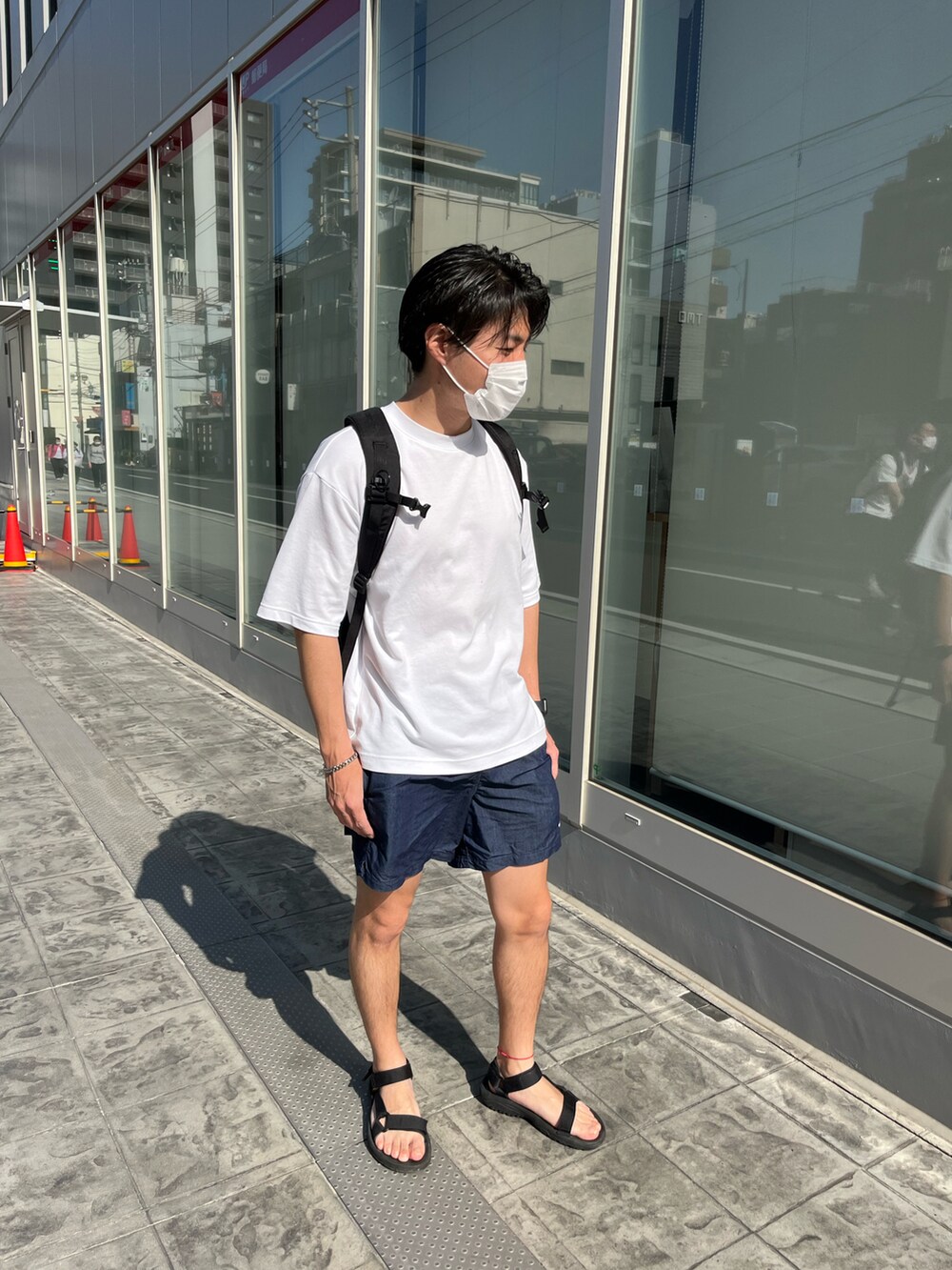 ブラック系のサンダル、ブルー系のその他パンツ、ホワイト系のTシャツ/カットソーを着用したメンズの春コーディネートの2枚目の写真