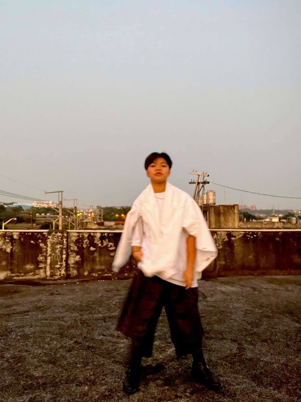 グリーン系のその他パンツ、ホワイト系のシャツ/ブラウス、ブラック系のブーツを着用したレディースの春コーディネートの2枚目の写真