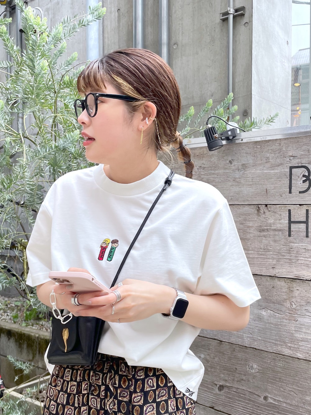 ホワイト系のTシャツ/カットソー、ブラック系のショルダーバッグ、ブラック系のサンダルを着用したレディースの春コーディネートの2枚目の写真