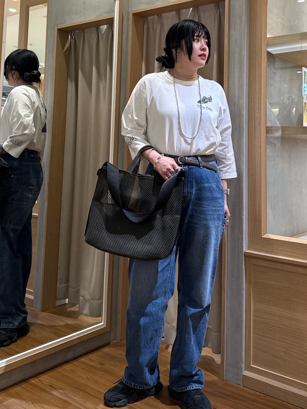 グリーン系のトートバッグ、ホワイト系のTシャツ/カットソーを着用したレディースの春コーディネートの2枚目の写真