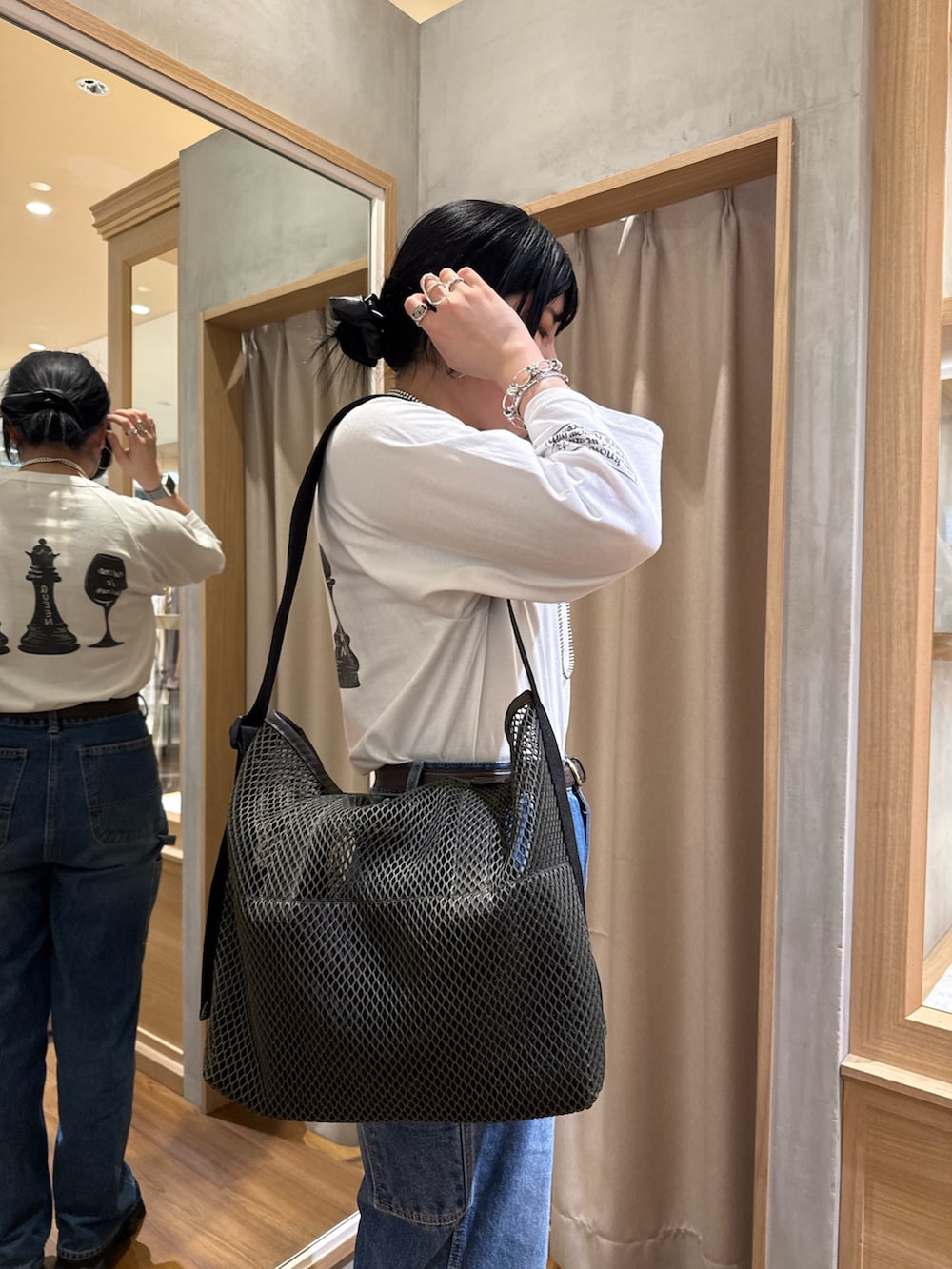 グリーン系のトートバッグ、ホワイト系のTシャツ/カットソーを着用したレディースの春コーディネートの3枚目の写真