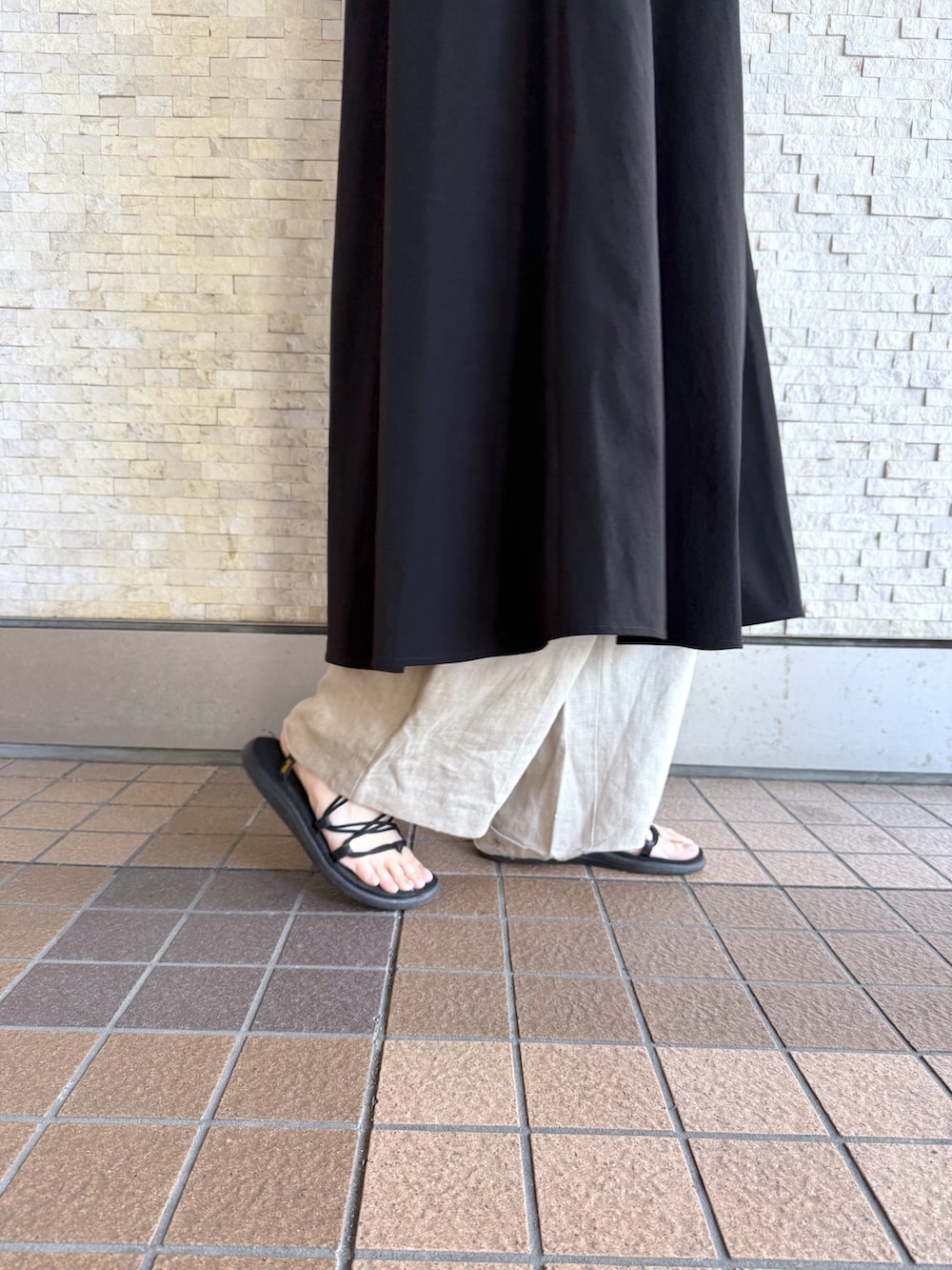 ブラック系のワンピース、ブラック系のショルダーバッグ、シルバー系のネックレスを着用したレディースの春コーディネートの3枚目の写真