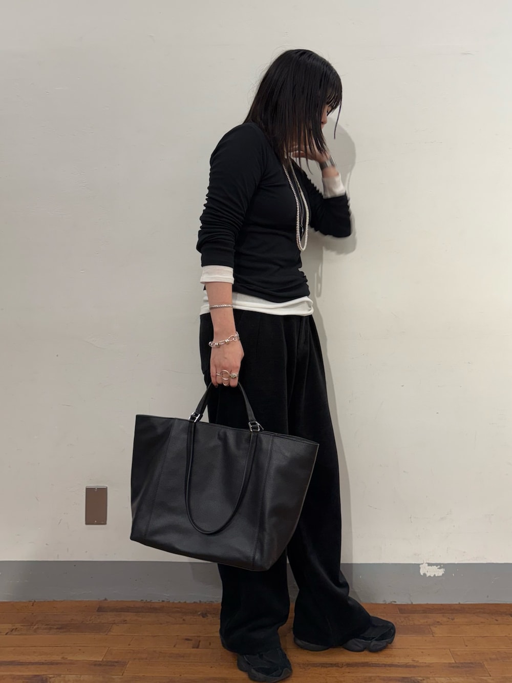 ブラック系のTシャツ/カットソー、ブラック系のトートバッグを着用したレディースの冬コーディネートの2枚目の写真