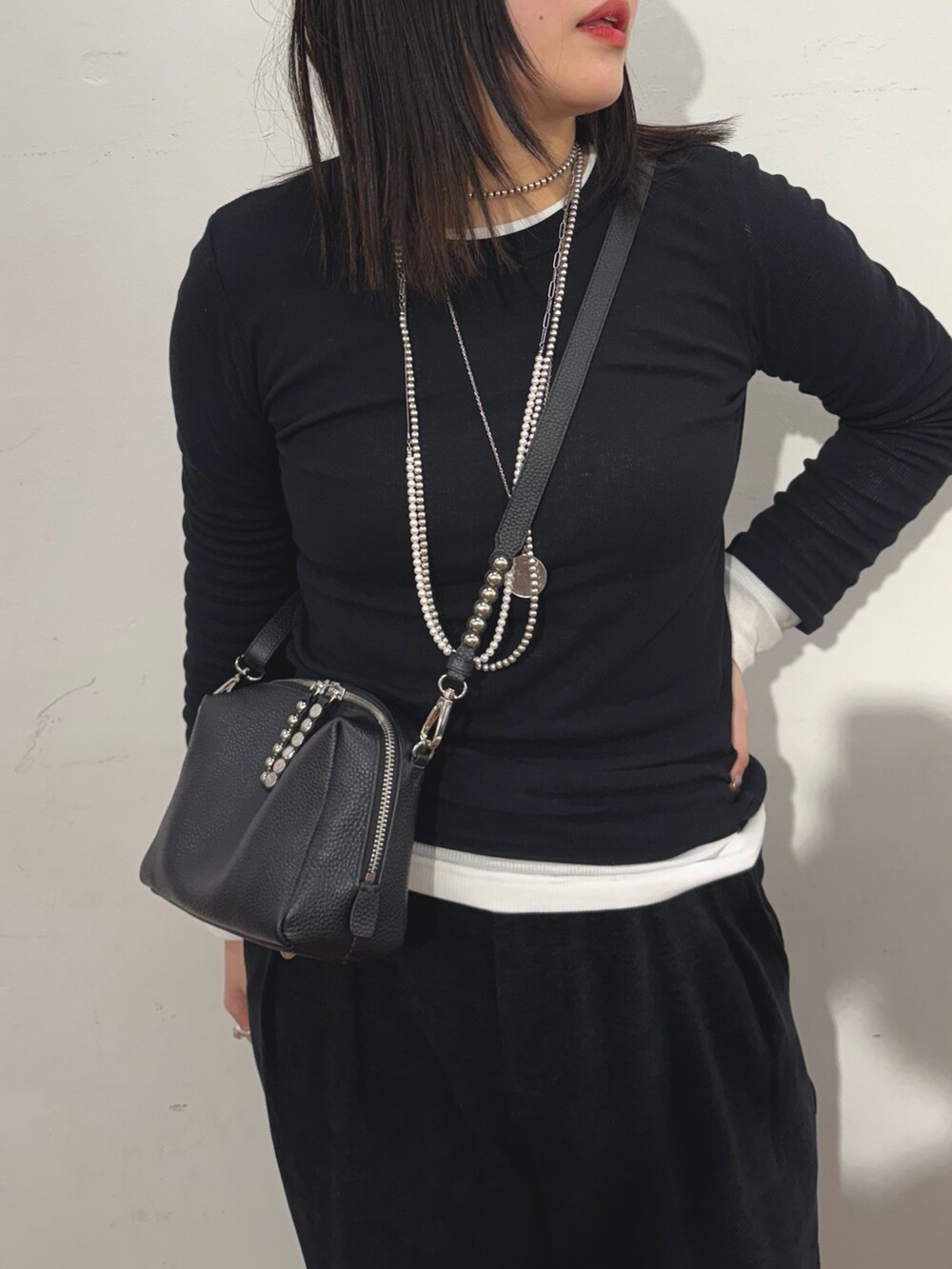 ブラック系のTシャツ/カットソー、ブラック系のショルダーバッグを着用したレディースの冬コーディネートの4枚目の写真