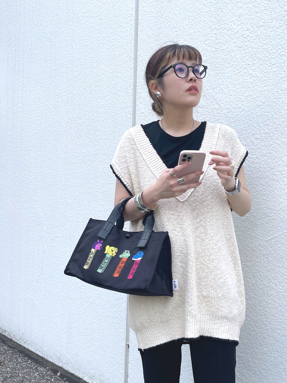 ブラック系のトートバッグ、ホワイト系のベストを着用したレディースの春コーディネートの3枚目の写真