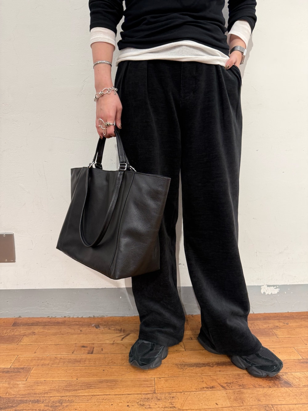 ブラック系のTシャツ/カットソー、ブラック系のトートバッグを着用したレディースの冬コーディネートの3枚目の写真