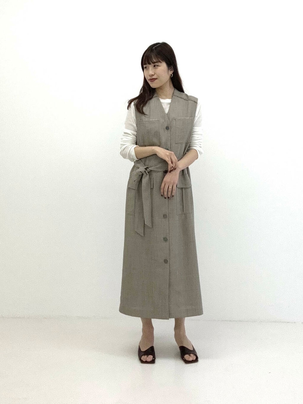 ブラウン系のワンピース、ホワイト系のTシャツ/カットソーを着用したレディースの春コーディネートの2枚目の写真