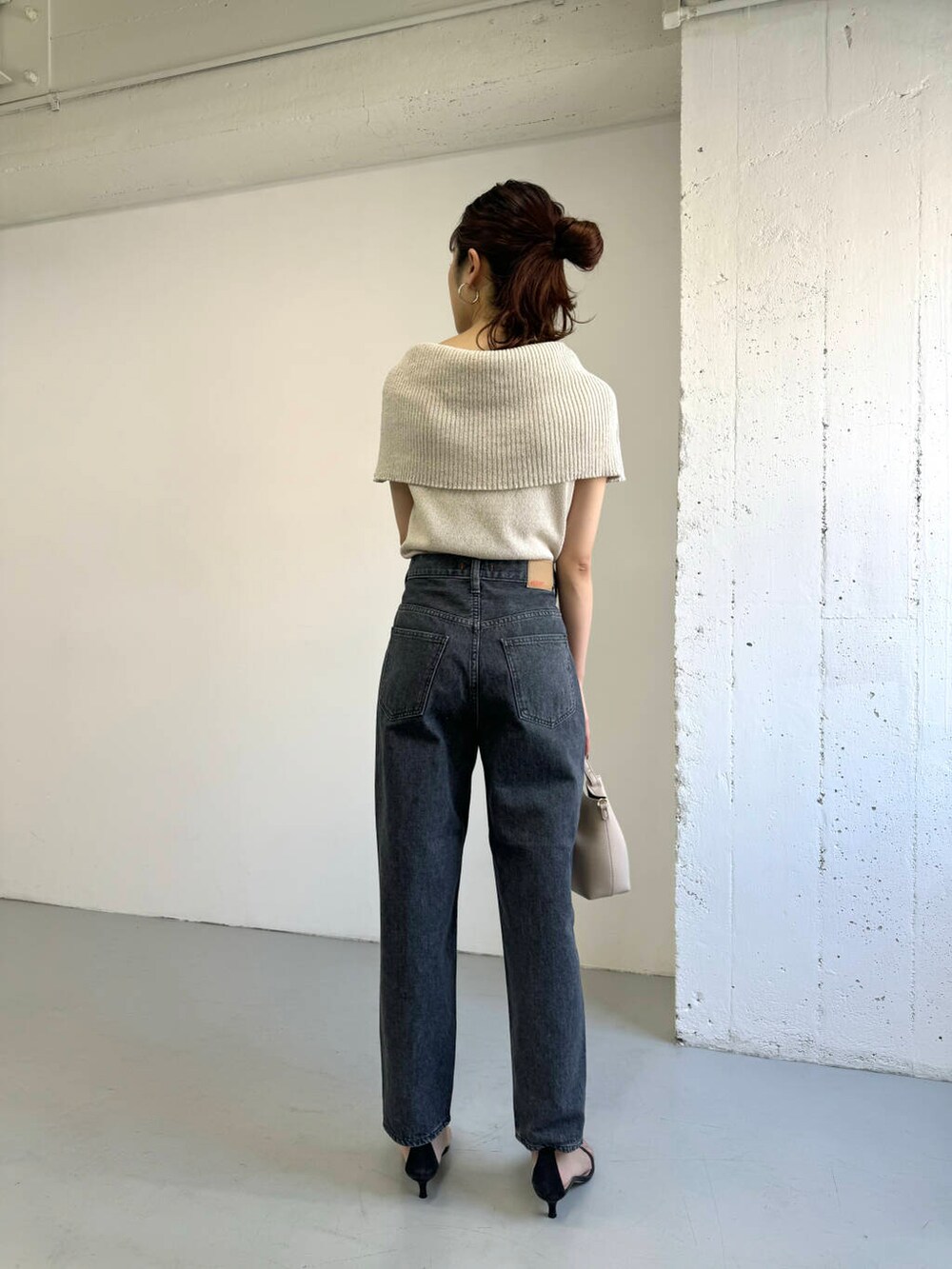 ベージュ系のニット/セーター、グレー系のデニムパンツを着用したレディースの夏コーディネートの5枚目の写真