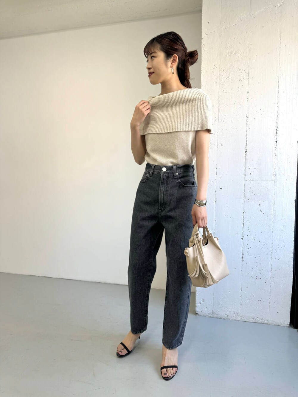 ベージュ系のニット/セーター、グレー系のデニムパンツを着用したレディースの夏コーディネートの2枚目の写真