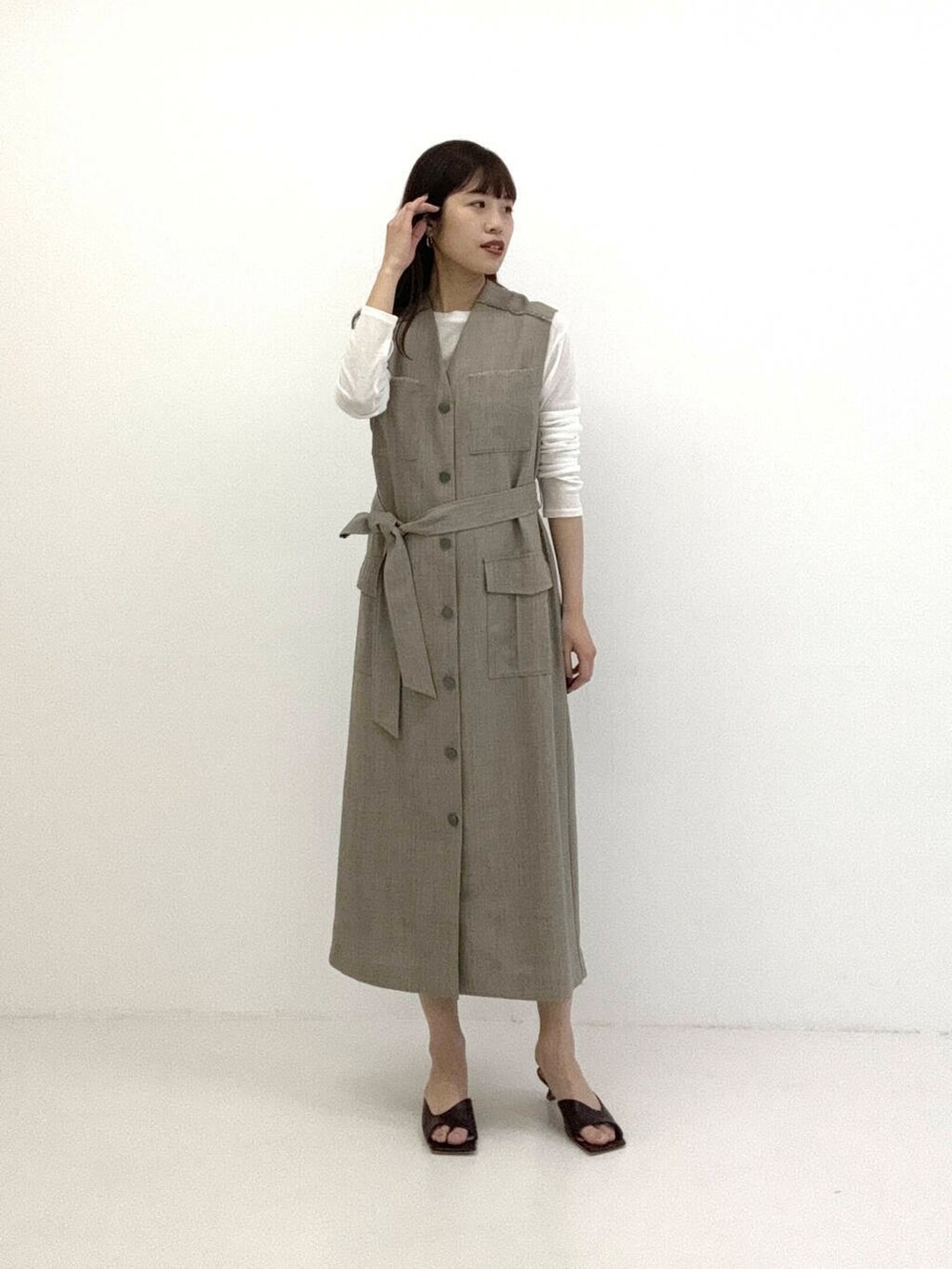 ブラウン系のワンピース、ホワイト系のTシャツ/カットソーを着用したレディースの春コーディネートの3枚目の写真