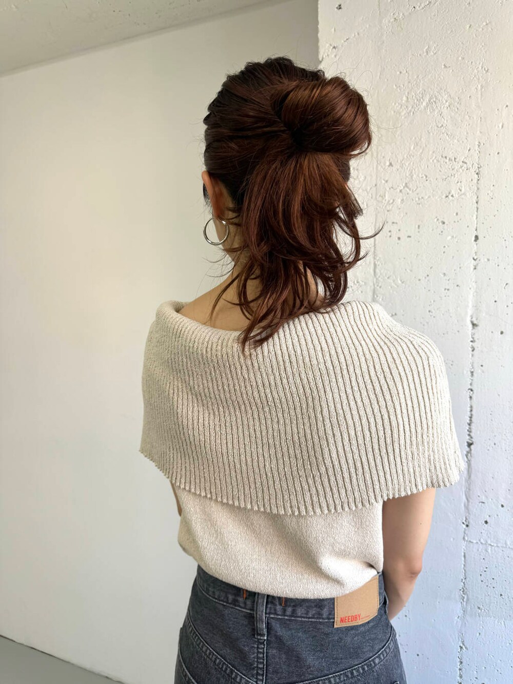 ベージュ系のニット/セーター、グレー系のデニムパンツを着用したレディースの夏コーディネートの8枚目の写真