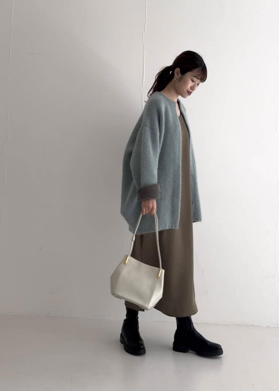 ブラウン系のワンピース、ホワイト系のトートバッグ、ブルー系のカーディガン/ボレロを着用したレディースの夏コーディネートの4枚目の写真