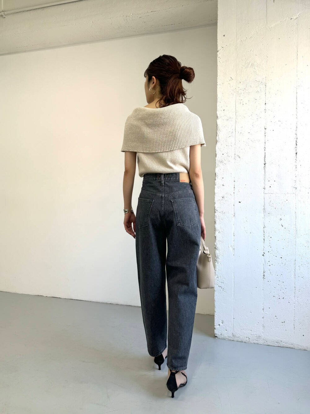 ベージュ系のニット/セーター、グレー系のデニムパンツを着用したレディースの夏コーディネートの4枚目の写真