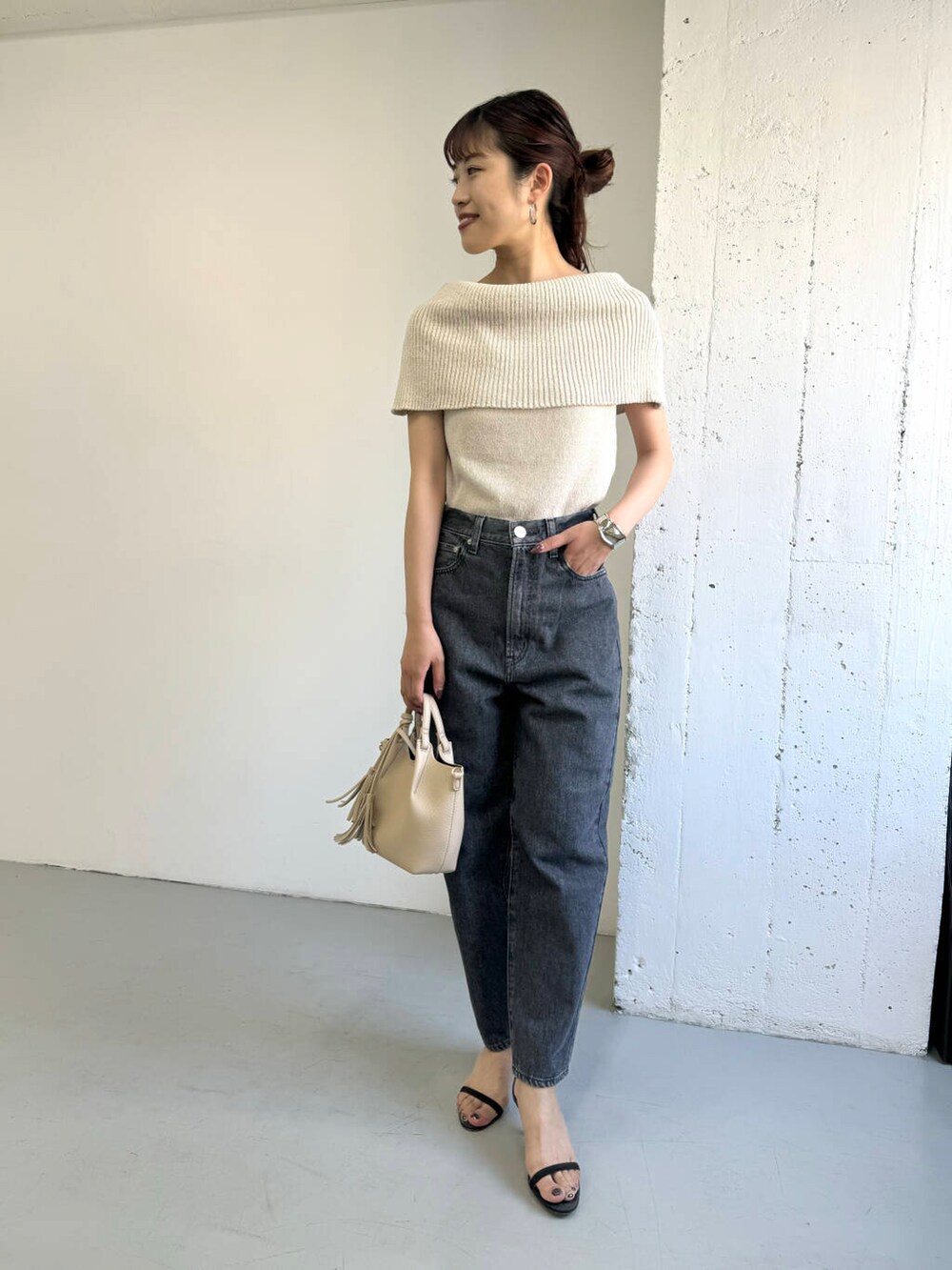 ベージュ系のニット/セーター、グレー系のデニムパンツを着用したレディースの夏コーディネートの3枚目の写真