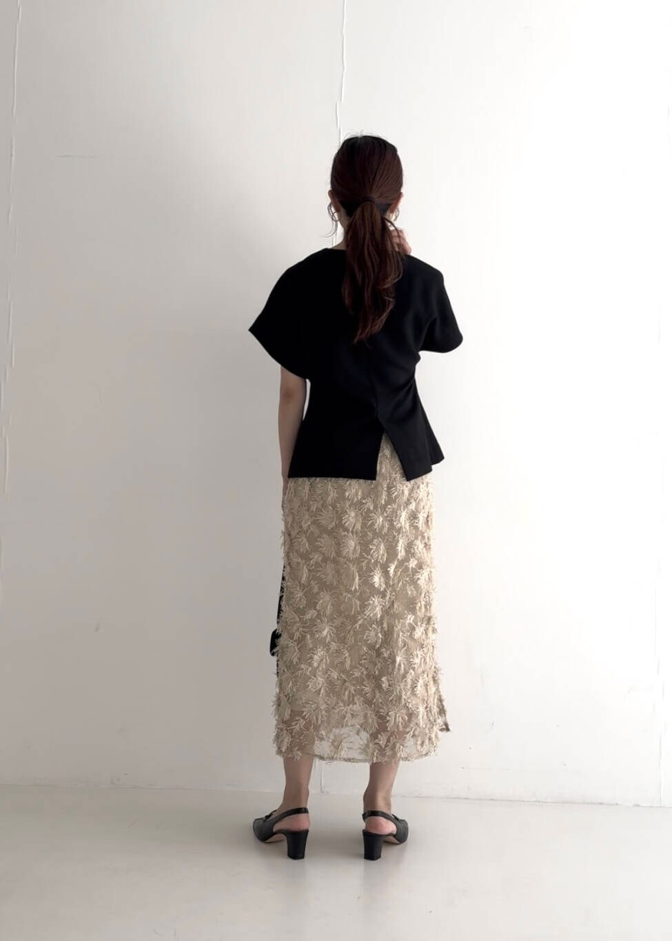 ブラック系のベスト、ベージュ系のスカート、ブラック系のショルダーバッグを着用したレディースの夏コーディネートの5枚目の写真