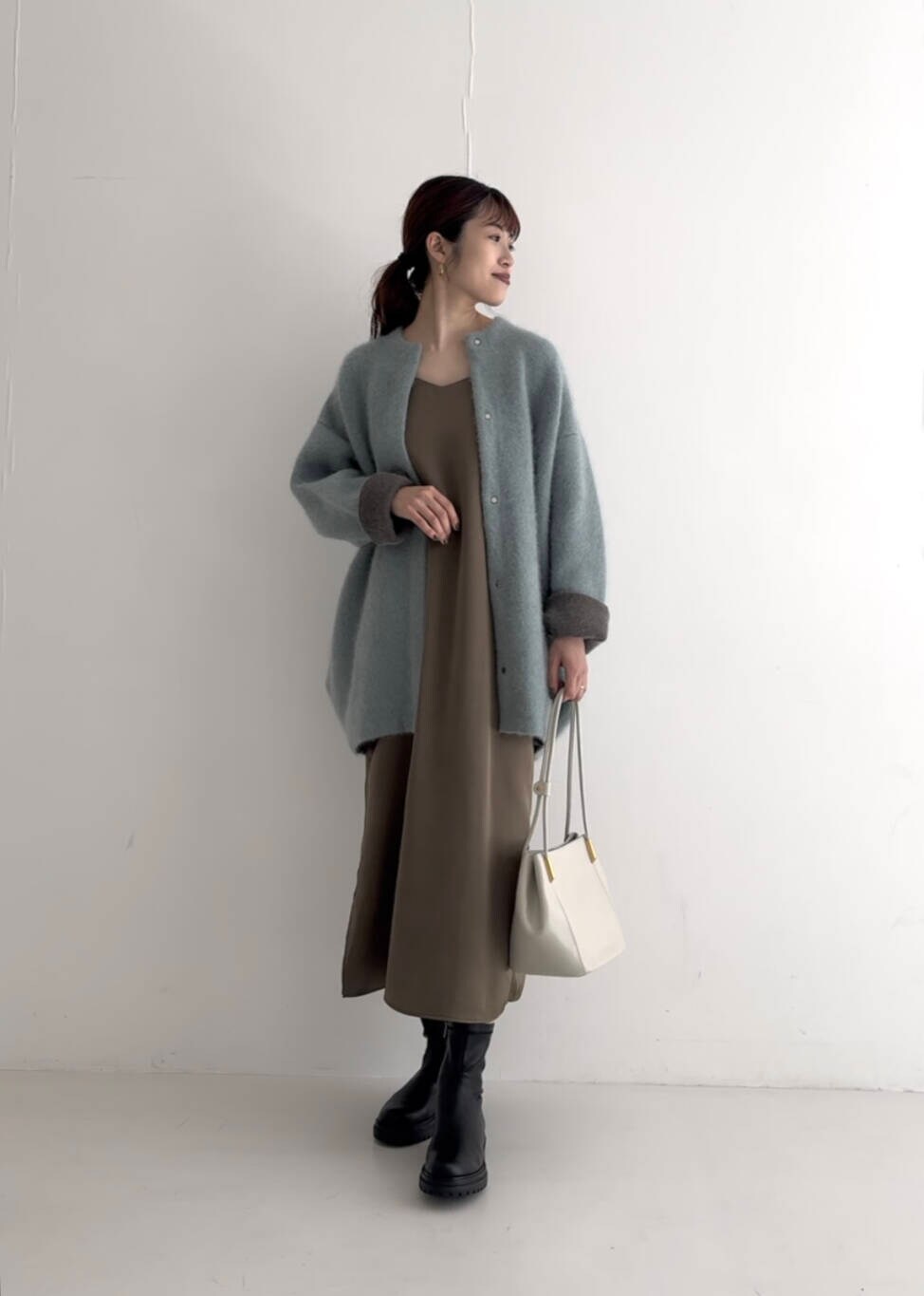 ブラウン系のワンピース、ホワイト系のトートバッグ、ブルー系のカーディガン/ボレロを着用したレディースの夏コーディネートの2枚目の写真