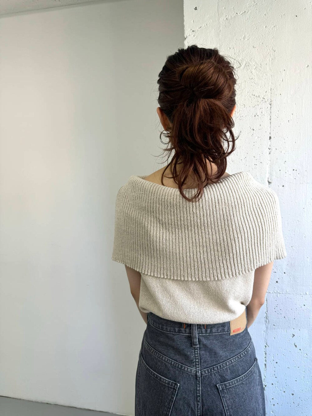 ベージュ系のニット/セーター、グレー系のデニムパンツを着用したレディースの夏コーディネートの7枚目の写真