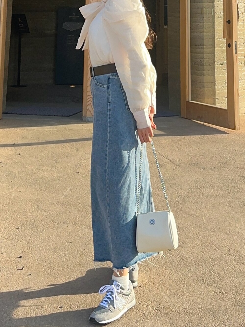 ホワイト系のシャツ/ブラウス、ホワイト系のショルダーバッグ、グレー系のスニーカーを着用したレディースの冬コーディネートの3枚目の写真